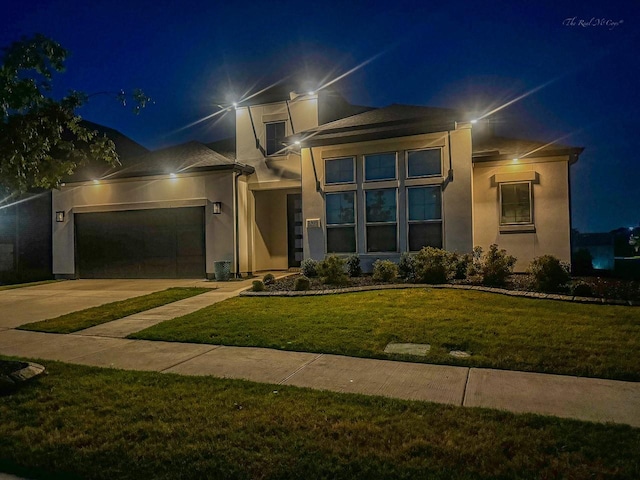 view of front of property featuring a garage and a lawn