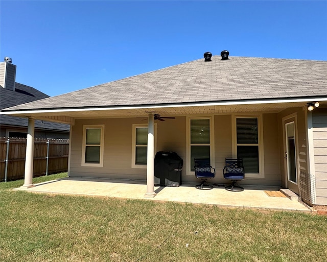 back of house featuring a lawn, ceiling fan, and a patio area