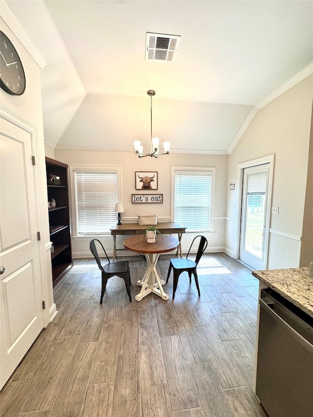 dining space with crown molding, wood-type flooring, a chandelier, and vaulted ceiling