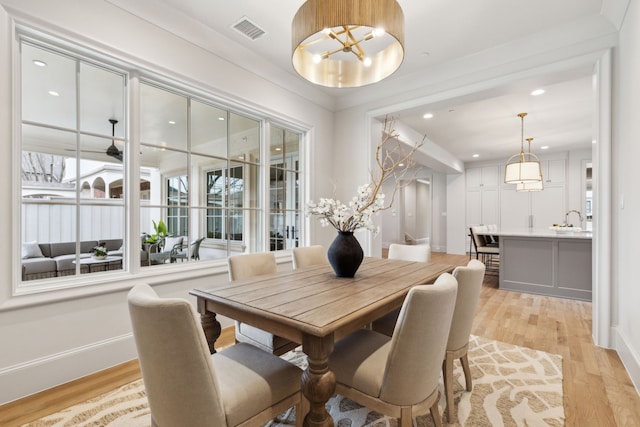 dining room featuring sink and light hardwood / wood-style floors