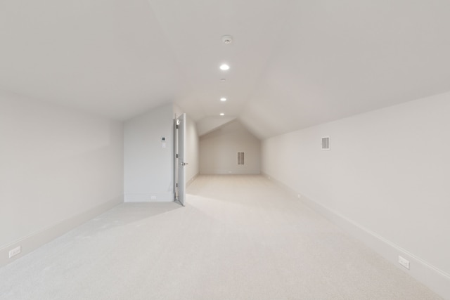 additional living space featuring lofted ceiling and light colored carpet