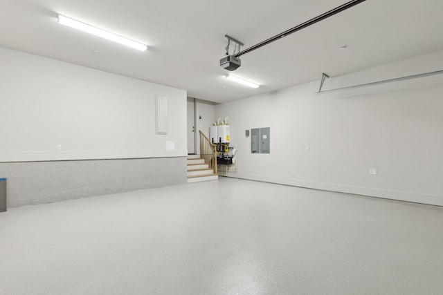 garage featuring tankless water heater, a garage door opener, and electric panel