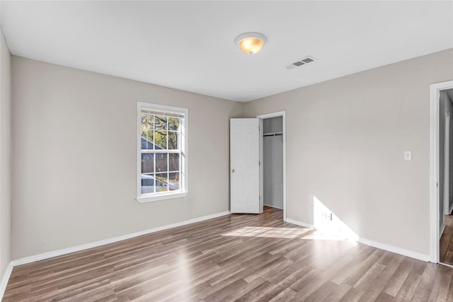 unfurnished bedroom with hardwood / wood-style floors and a closet