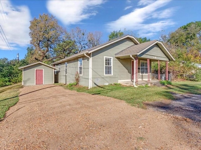 view of front facade featuring a porch and a storage shed