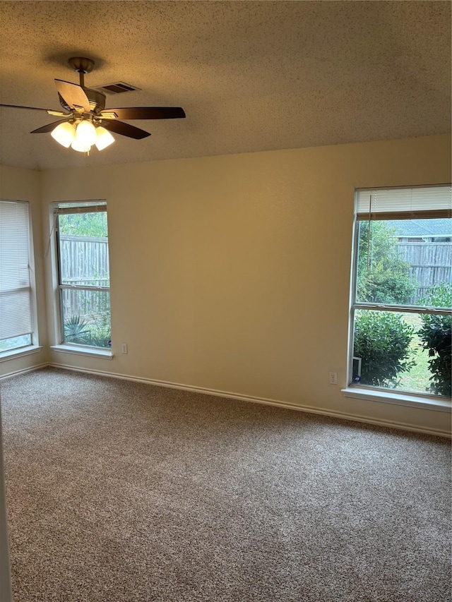 carpeted spare room with ceiling fan and a textured ceiling