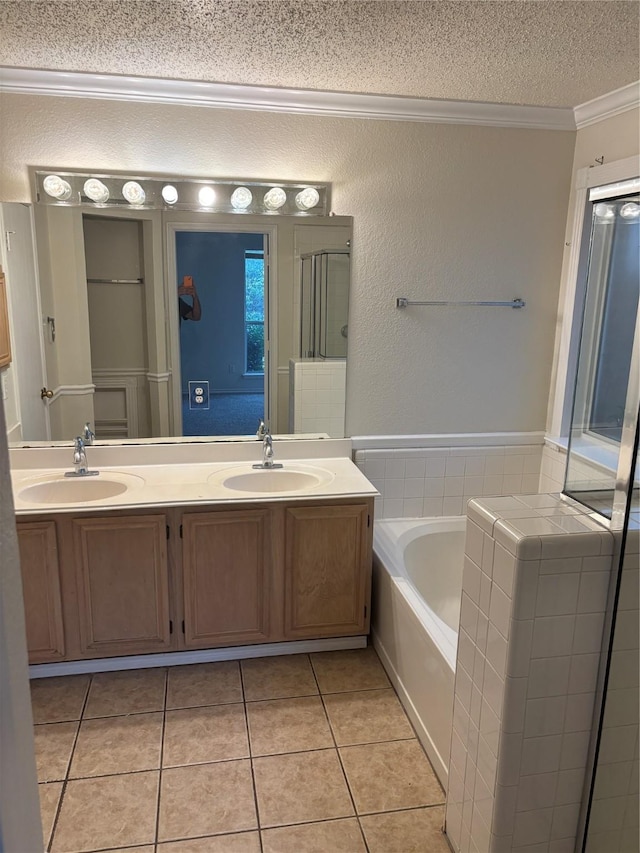 bathroom featuring tile patterned floors, a textured ceiling, ornamental molding, vanity, and independent shower and bath