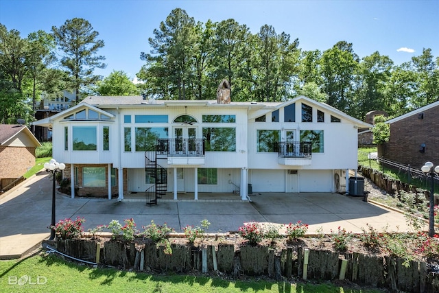 back of house featuring central AC, a balcony, and a patio area