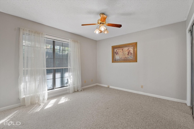 carpeted empty room featuring ceiling fan and a textured ceiling