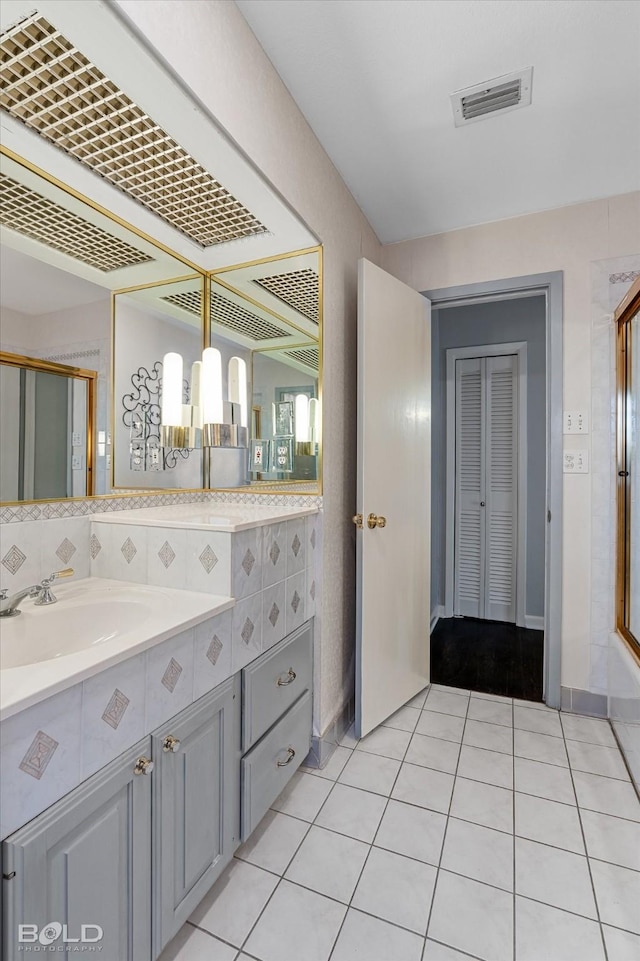 bathroom with walk in shower, vanity, tile patterned flooring, and decorative backsplash