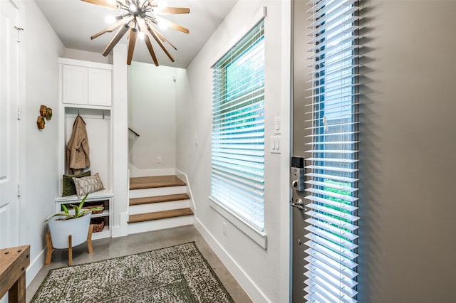 mudroom with plenty of natural light, concrete flooring, and a chandelier