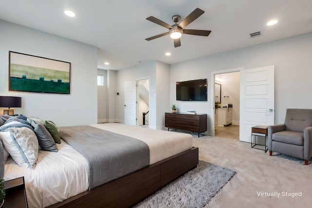 bedroom with connected bathroom and light colored carpet