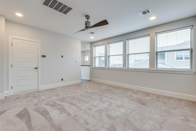 spare room featuring light colored carpet and ceiling fan