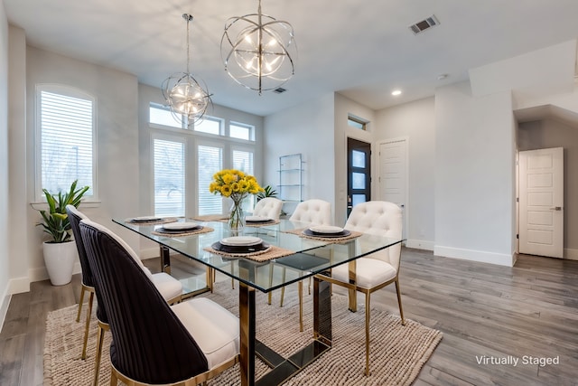 dining space featuring an inviting chandelier and hardwood / wood-style flooring