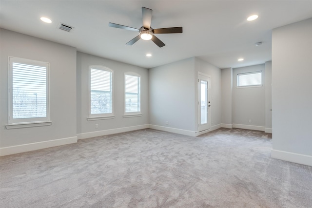 carpeted spare room featuring ceiling fan