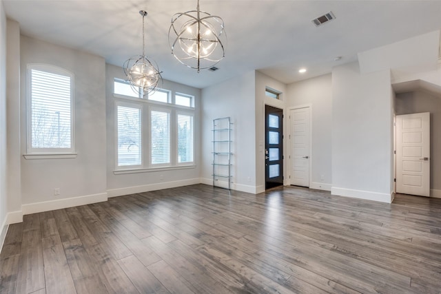 unfurnished room featuring a notable chandelier and dark hardwood / wood-style floors