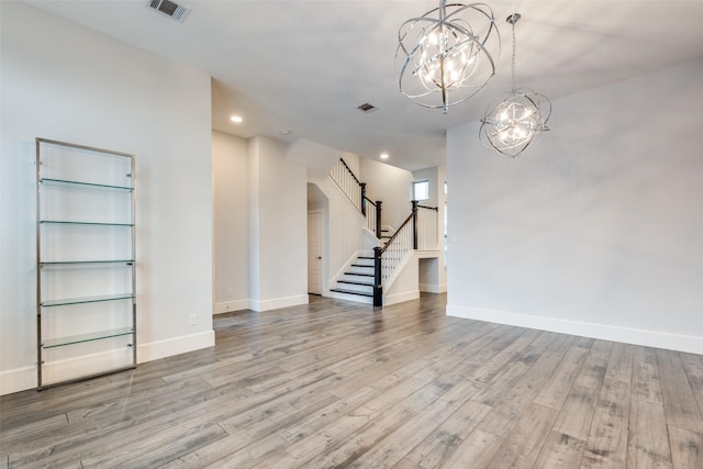 empty room featuring light hardwood / wood-style floors and a chandelier