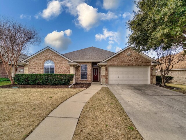 ranch-style home featuring a garage and a front lawn