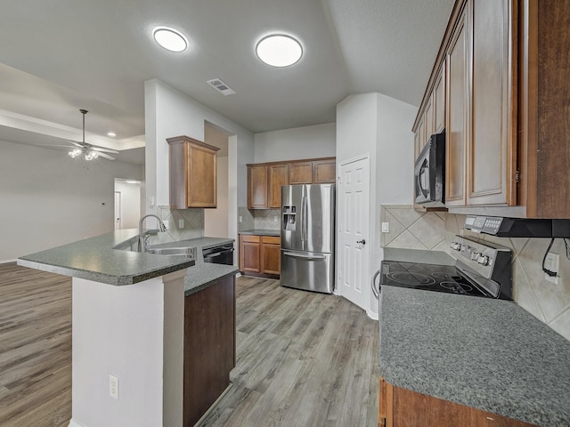 kitchen featuring sink, light hardwood / wood-style flooring, ceiling fan, black appliances, and kitchen peninsula