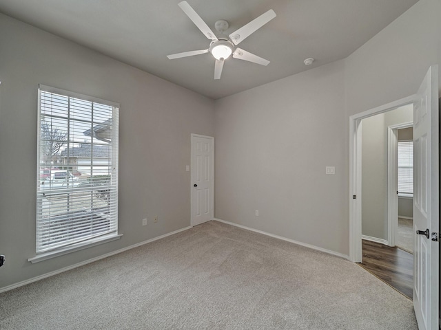 carpeted spare room with ceiling fan