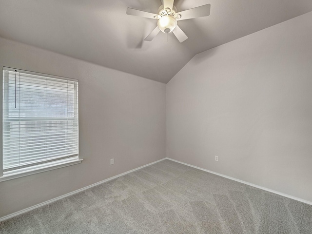 spare room with ceiling fan, lofted ceiling, and light carpet