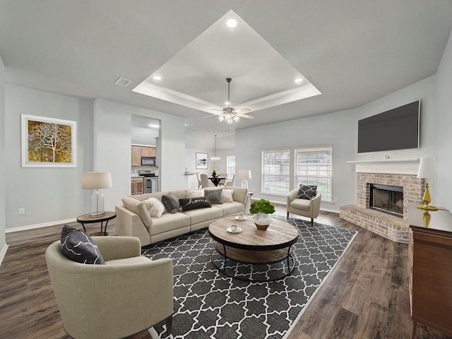 821 Grace Ln, Saginaw, TX 76179 - living area featuring baseboards, dark wood-style floors, a brick fireplace, a raised ceiling, and recessed lighting
