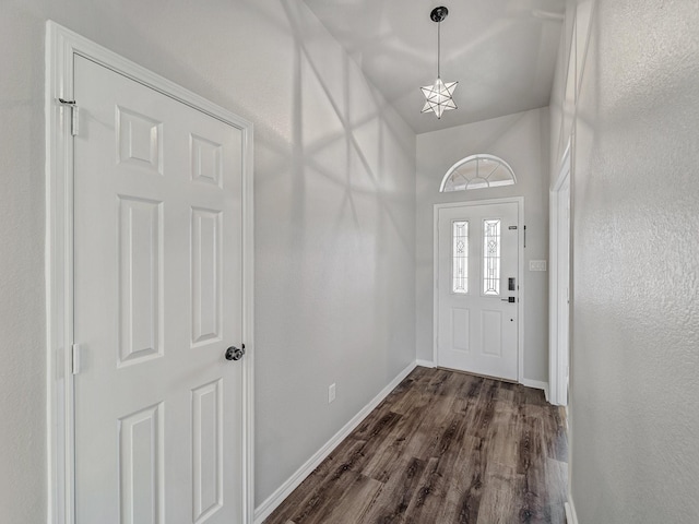 doorway with dark hardwood / wood-style floors and an inviting chandelier