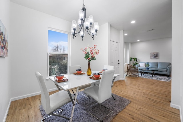 dining area featuring an inviting chandelier and hardwood / wood-style flooring