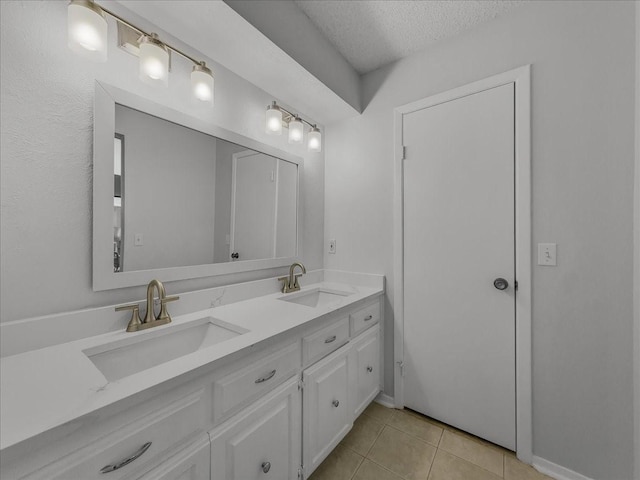 bathroom featuring tile patterned floors, vanity, and a textured ceiling