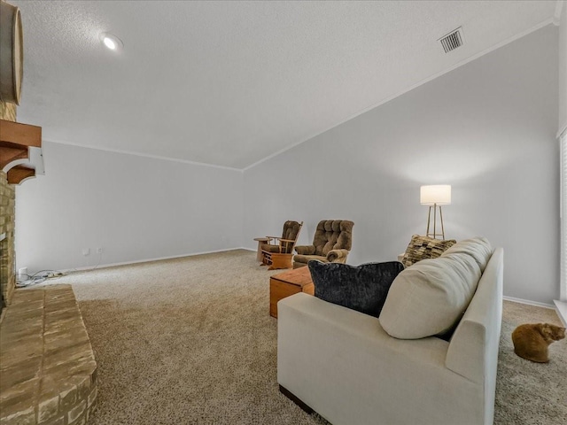 carpeted living room featuring lofted ceiling, ornamental molding, a fireplace, and a textured ceiling