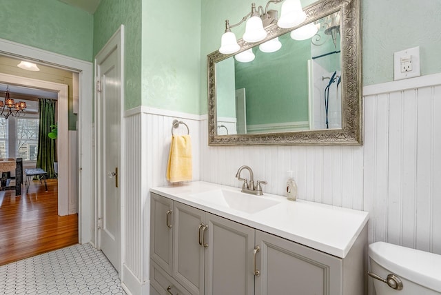 bathroom featuring vanity, toilet, and an inviting chandelier