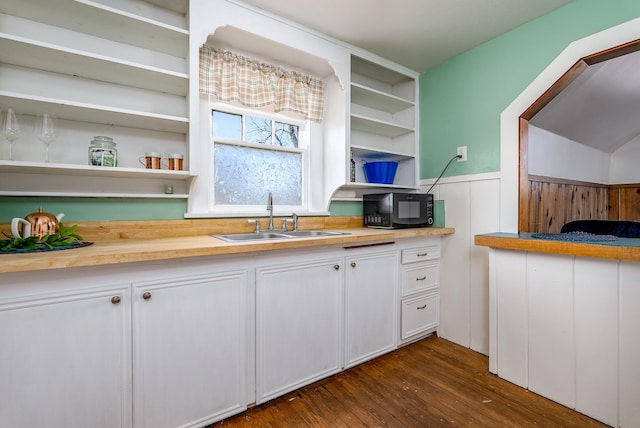 kitchen featuring white cabinetry, wood counters, dark wood-type flooring, and sink