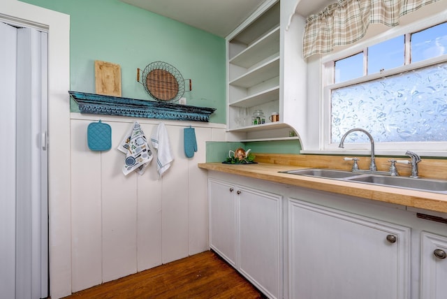 kitchen featuring wooden counters, dark hardwood / wood-style floors, sink, and white cabinets