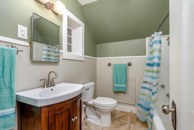 full bathroom with vaulted ceiling, tile patterned flooring, vanity, shower / tub combo, and toilet