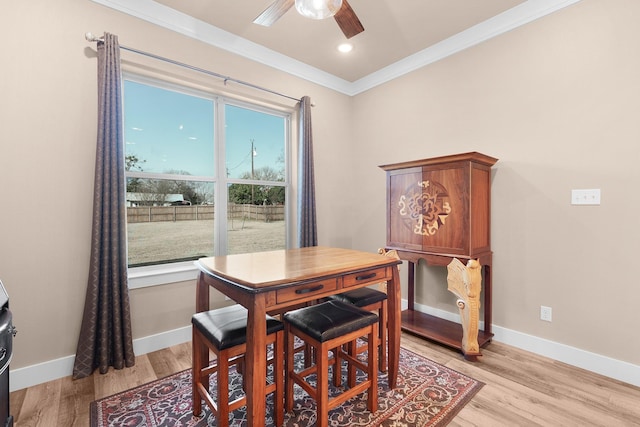 dining area with crown molding, ceiling fan, and light hardwood / wood-style flooring