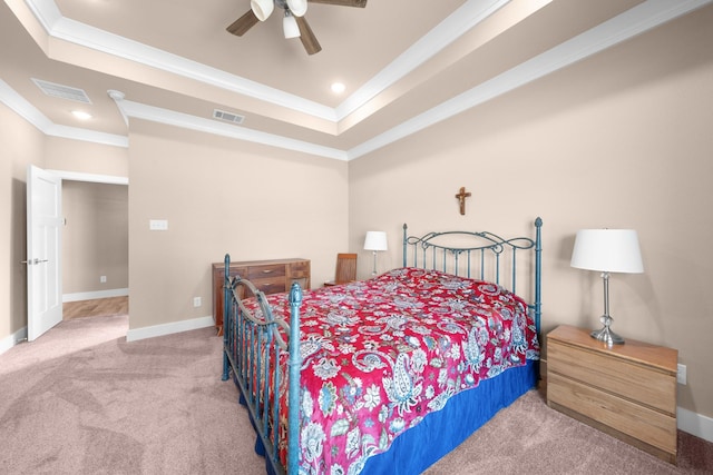 carpeted bedroom featuring crown molding, ceiling fan, and a tray ceiling