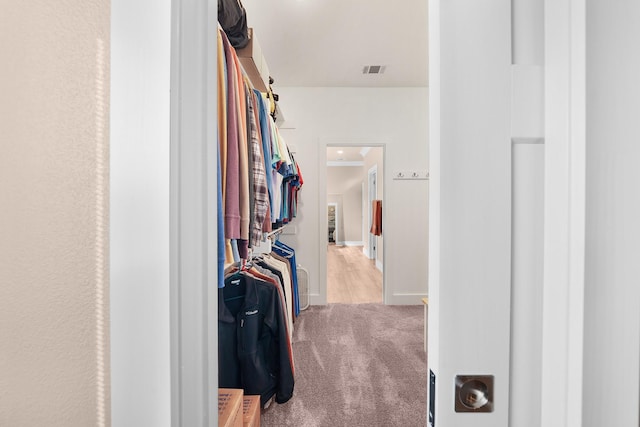 walk in closet featuring light carpet