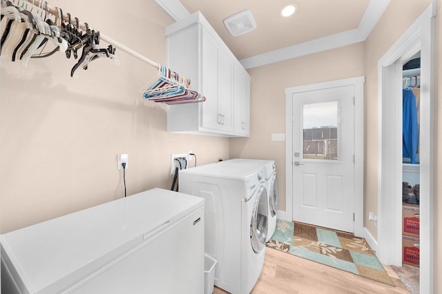 laundry room with cabinets, separate washer and dryer, and light wood-type flooring