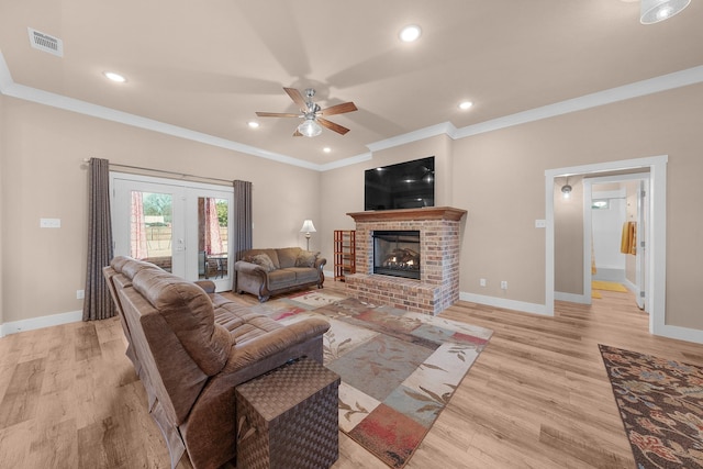 living room featuring ornamental molding, a brick fireplace, ceiling fan, and light hardwood / wood-style floors