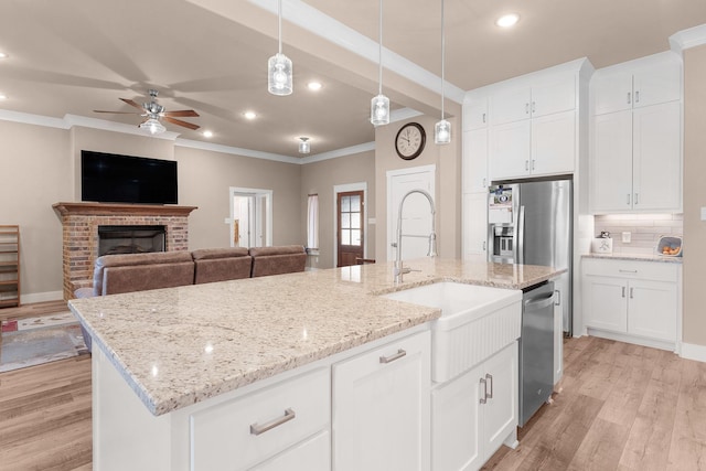 kitchen with white cabinetry, pendant lighting, a kitchen island with sink, and stainless steel appliances