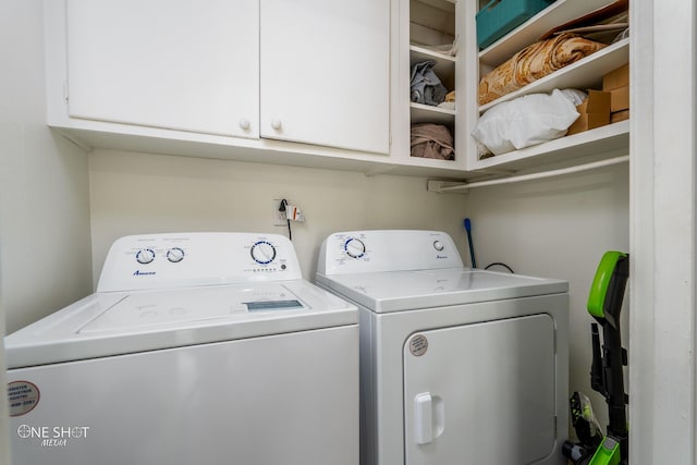 clothes washing area featuring cabinets and washer and clothes dryer