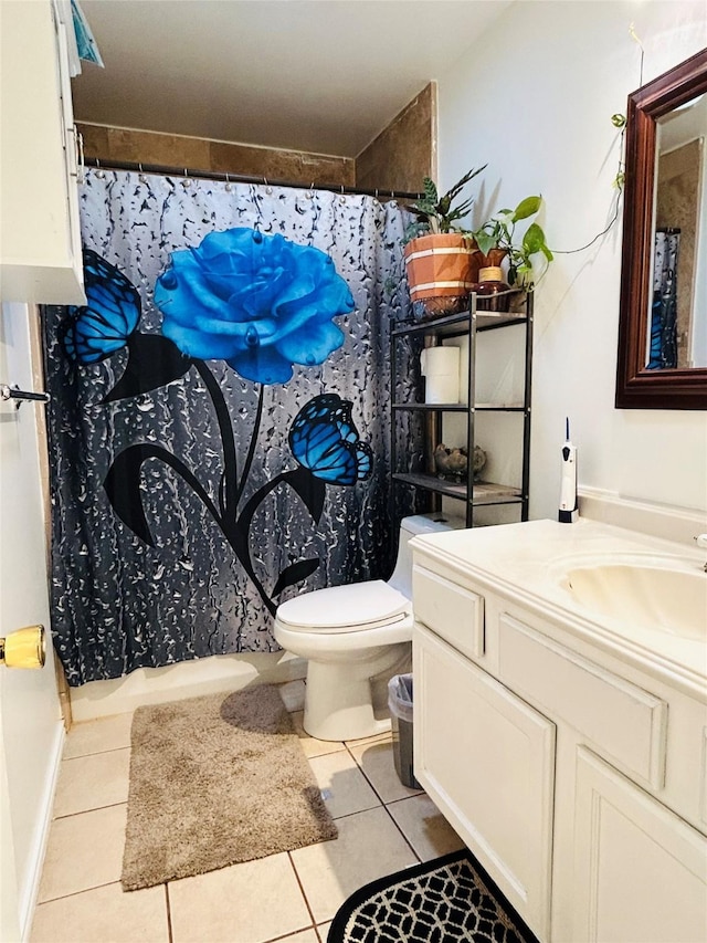 bathroom featuring walk in shower, vanity, toilet, and tile patterned flooring