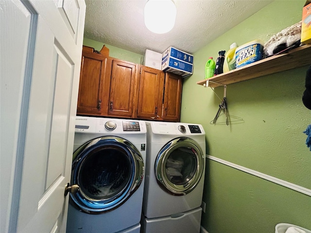 laundry room with cabinets, washing machine and dryer, and a textured ceiling