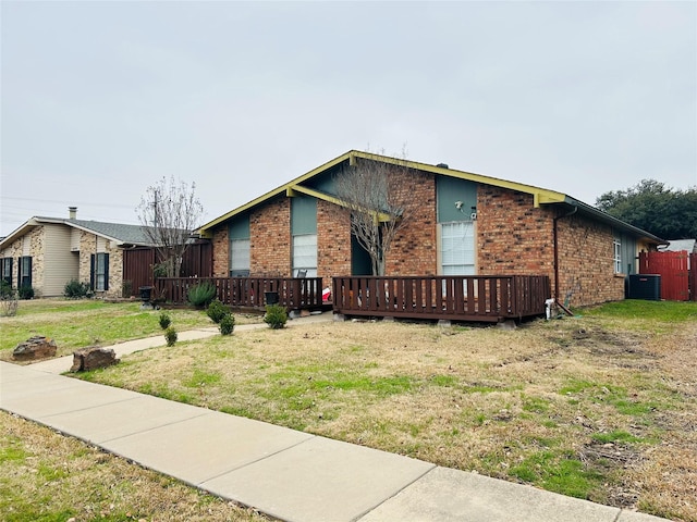 ranch-style home with central AC unit and a front lawn