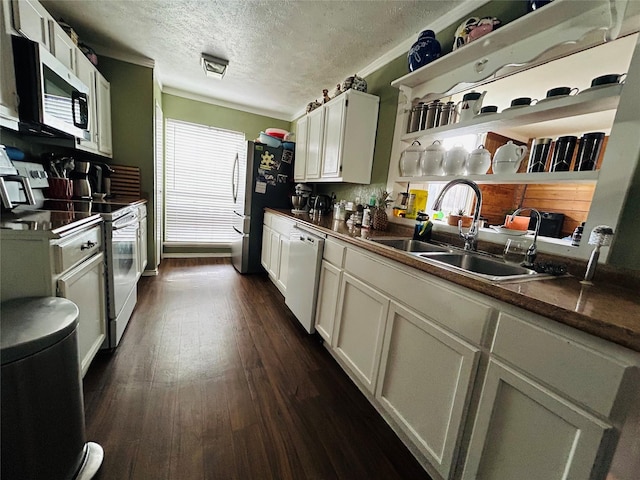 kitchen featuring appliances with stainless steel finishes, dark hardwood / wood-style floors, white cabinetry, sink, and a textured ceiling