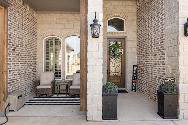 view of exterior entry featuring stone siding and brick siding