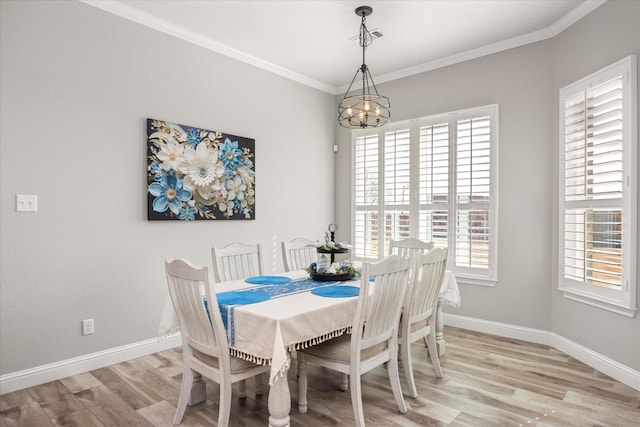 dining room with light wood finished floors, visible vents, an inviting chandelier, ornamental molding, and baseboards