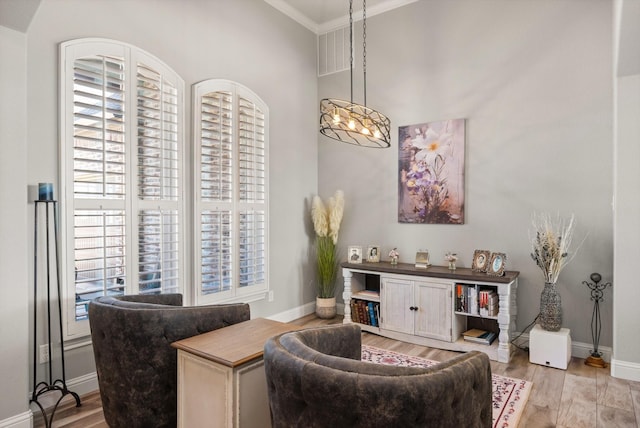 sitting room featuring light wood-type flooring, a wealth of natural light, and baseboards