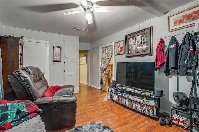 living room featuring wood-type flooring and ceiling fan