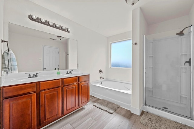 bathroom featuring hardwood / wood-style flooring, shower with separate bathtub, and vanity