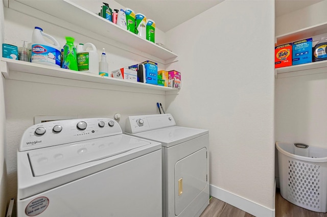 clothes washing area featuring separate washer and dryer and hardwood / wood-style flooring